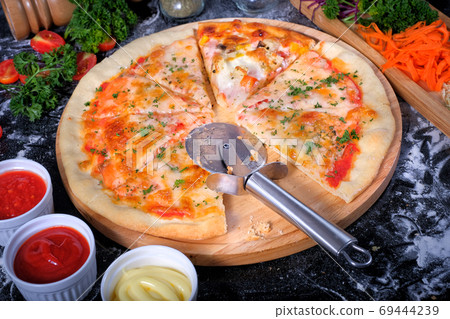 Salmon Seafood Pizza on a Black table with ingredients around Salmon Seafood Pizza on a Black table with ingredients around 69444239