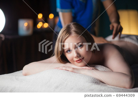 Massage concept. Young attractive woman reciving relaxing massage 69444309