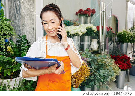 Woman ordering flowers for store Woman ordering flowers for store 69444779
