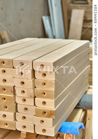 Joinery. Wooden table legs. Stacked wooden table legs in workshop Joinery. Wooden table legs. Stacked wooden table legs in workshop 69445384