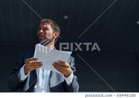 Business man outdoors with documents in hands near building official lifestyle Business man outdoors with documents in hands near building official lifestyle 69446180