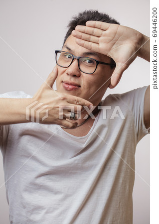 Funny Korean man in spectacles and t-shirt showing camera sign 69446200