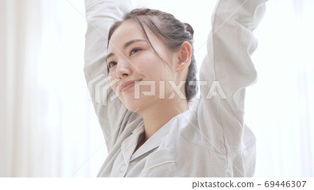 Young woman in pajamas waking up Young woman in pajamas waking up 69446307