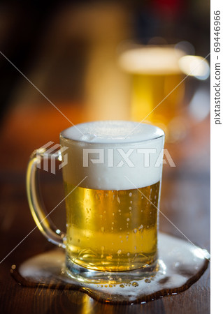Glass of light beer on wooden table. Glass of light beer on wooden table. 69446966