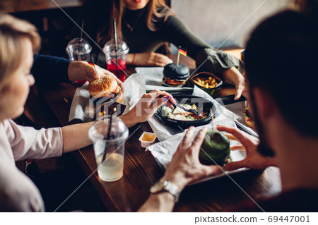 Burgers with vegetables and fries on a wooden board, top view. 69447001