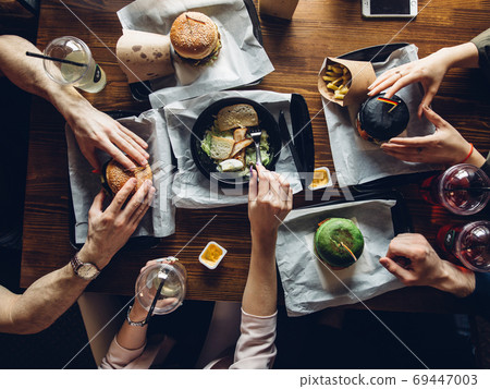 Burgers with vegetables and fries on a wooden board, top view. 69447003