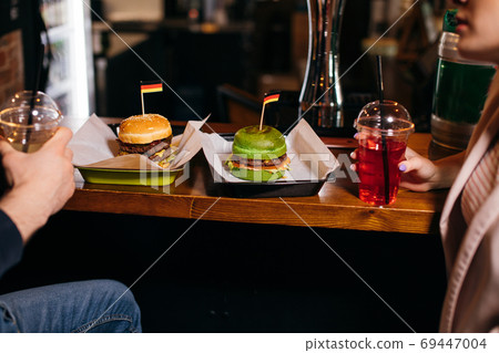 Group of young people are enjoying their delicious burgers in the burger-bar 69447004