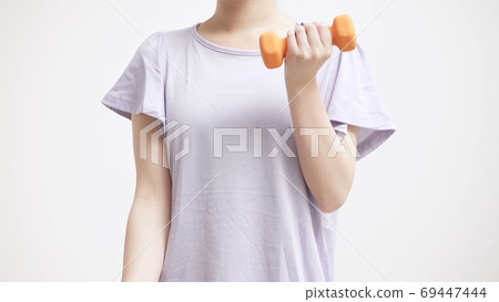 Young woman doing muscle training with dumbbells 69447444