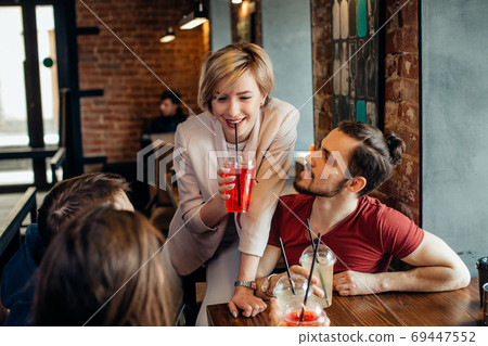 Happy friends drinking beverages having fun while spending time together in cafe Happy friends drinking beverages having fun while spending time together in cafe 69447552