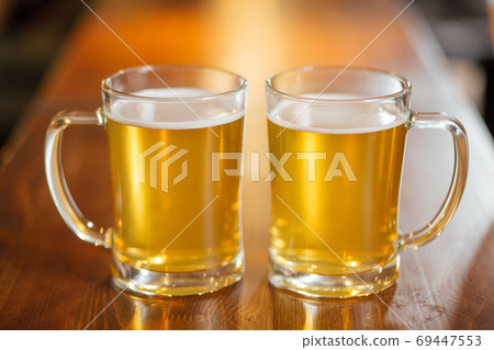 Glass of light beer on wooden table. Glass of light beer on wooden table. 69447553