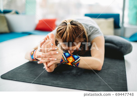 Yogi girl practicing Janu sirshasana or Head-to-Knee Forward Bend Pose 69447748