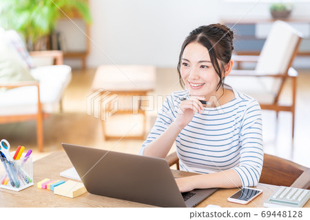 一個少婦遠程辦公在客廳。. 69448128