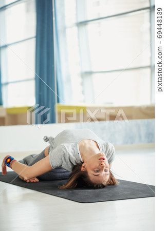 Attractive young woman lying in Shavasanaor Dead Body Posture. 69448189