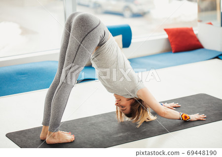 woman yoga exercices Adho Mukha Svanasana 69448190