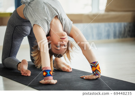 adult woman in supta virasana yoga position in studio 69448235