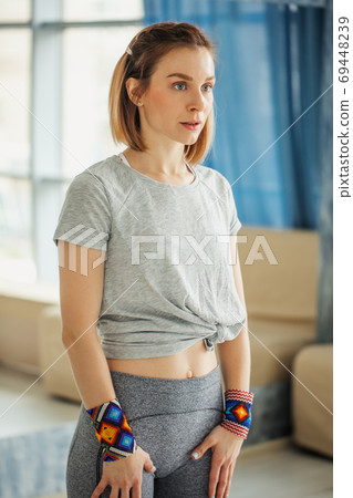 Side view of strong woman standing in the gym. Preparing to workout. 69448239