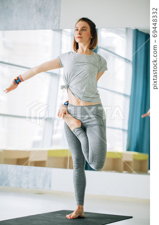 Female in sport clothes performing yoga exercise Tree 69448332