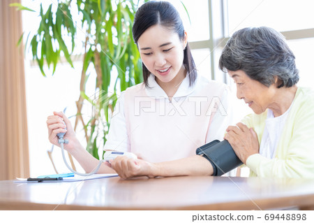 高級婦女和護理人員測量血壓的護理人員 高級婦女和護理人員測量血壓的護理人員 69448898