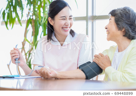 高級婦女和護理人員測量血壓的護理人員 高級婦女和護理人員測量血壓的護理人員 69448899