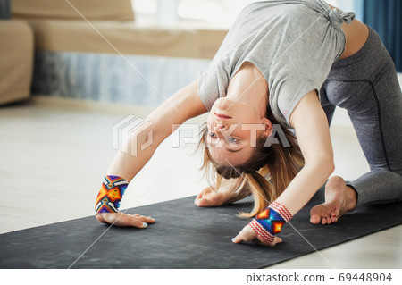 adult woman in supta virasana yoga position in studio adult woman in supta virasana yoga position in studio 69448904
