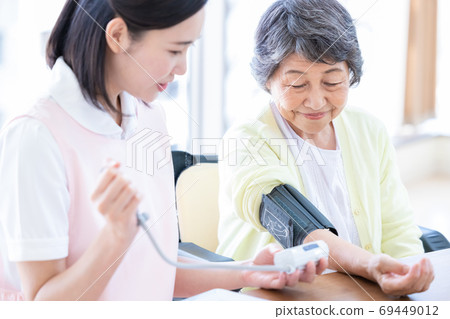 Senior women and caregivers Caregivers who measure blood pressure Senior women and caregivers Caregivers who measure blood pressure 69449012