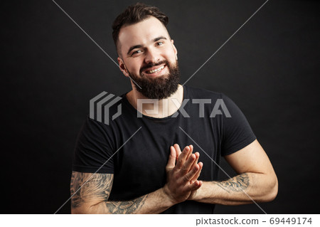 Portrait of handsome young man in casual t-shirt over black background. 69449174
