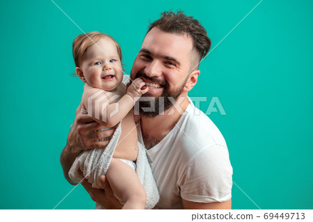 Playful father carrying his smiling infant child on neck over blue background Playful father carrying his smiling infant child on neck over blue background 69449713