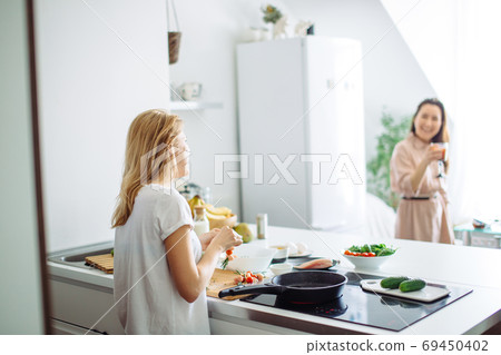 Closeup of woman roasting kebabs on frying pan 69450402