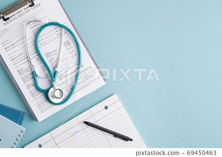 Top view of medical history form in clipboard, stethoscope and other stuff Top view of medical history form in clipboard, stethoscope and other stuff 69450463