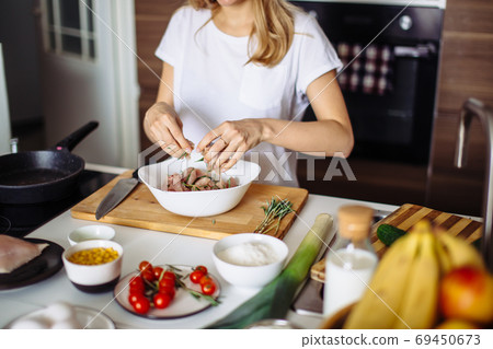 Home cozy kitchen chef pours salt on pork or beef meat with salt shaker Barbecue concept or healthy meat lifestyle shot Home cozy kitchen chef pours salt on pork or beef meat with salt shaker Barbecue concept or healthy meat lifestyle shot 69450673