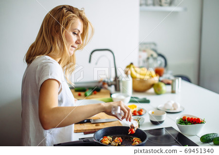 Closeup of woman roasting kebabs on frying pan 69451340