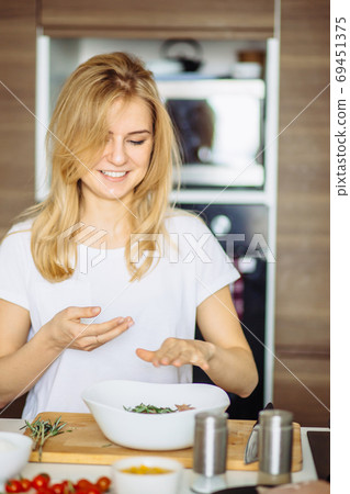 Closeup woman's hands cooking marinated shashlik or shish kebab, chicken meat on wooden skewer with onion on wood board, close up. Closeup woman's hands cooking marinated shashlik or shish kebab, chicken meat on wooden skewer with onion on wood board, close up. 69451375