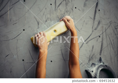 Climber hands holding artificial boulder in climbing gym, closeup shot 69451632