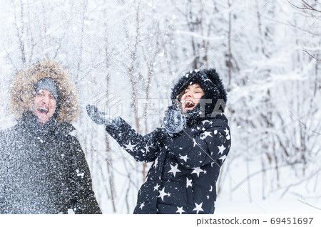 Young couple playing with snow in winter park Young couple playing with snow in winter park 69451697