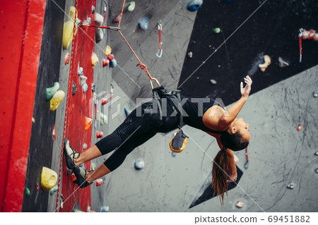 Active happy woman overhanging on tightrope in the training climbing center 69451882