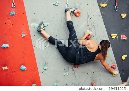Beautiful young woman taking a big step up an artificial wall 69451925