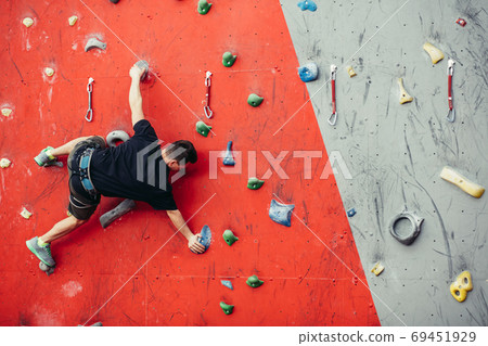 Man on artificial exercise climbing wall Man on artificial exercise climbing wall 69451929