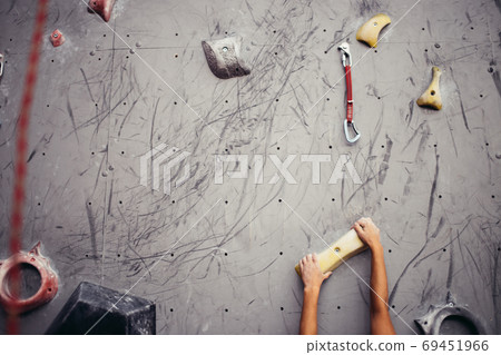 Climber hands holding artificial boulder in climbing gym, closeup shot Climber hands holding artificial boulder in climbing gym, closeup shot 69451966