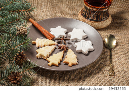 Gingerbread cookies in Christmas tree and star shape on plate Gingerbread cookies in Christmas tree and star shape on plate 69452363