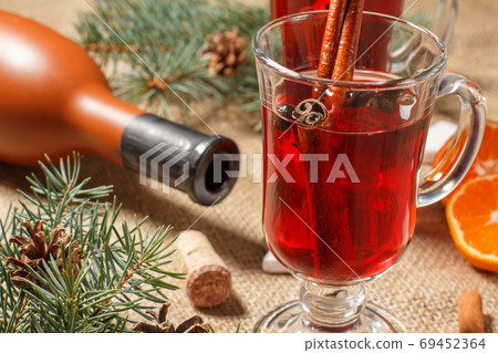 Glasses of Christmas mulled wine with spices and orange on sackcloth Glasses of Christmas mulled wine with spices and orange on sackcloth 69452364