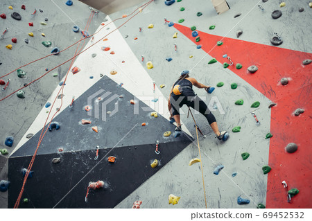 Beautiful young woman taking a big step up an artificial wall 69452532