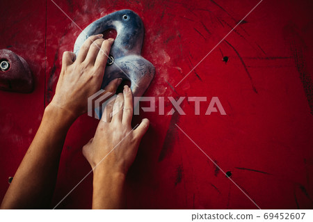 Female climber hands holding artificial boulder in climbing gym, closeup shot 69452607