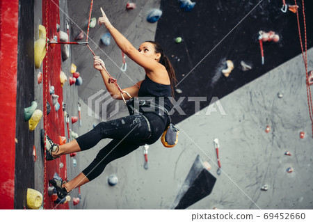 Active happy woman overhanging on tightrope in the training climbing center 69452660