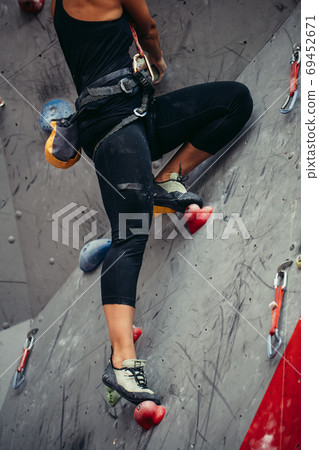 Close up of athletic woman practicing rock climbing on artificial wall indoors. 69452671