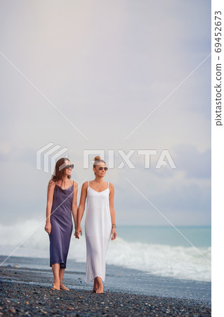 Young women in white on the beach 69452673