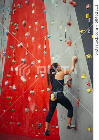Rear view of sportswoman looking at climbing wall Rear view of sportswoman looking at climbing wall 69452811