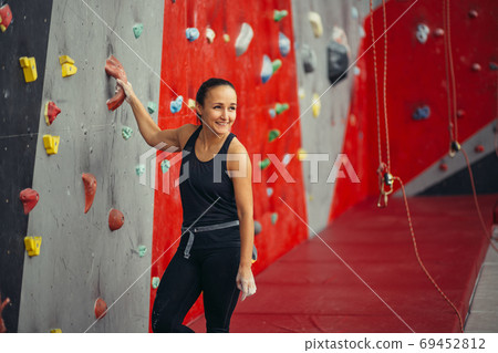 Rear view of sportswoman looking at climbing wall Rear view of sportswoman looking at climbing wall 69452812