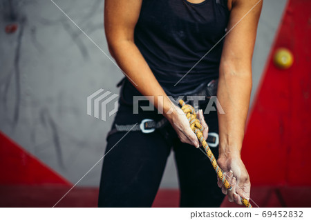 Rock climber wearing safety harness and safety rope in, close-up image Rock climber wearing safety harness and safety rope in, close-up image 69452832