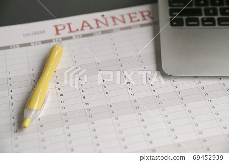 Computer laptop and pen on top of calendar planner 69452939