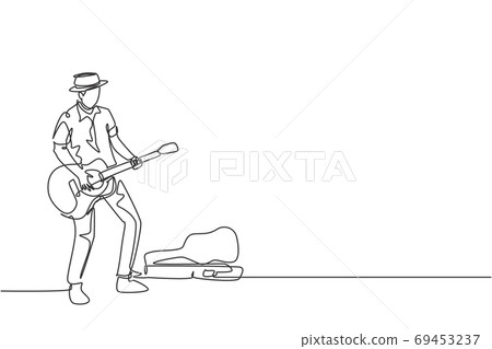 One continuous line drawing of young happy male guitarist standing and busking by playing guitar on city road 69453237